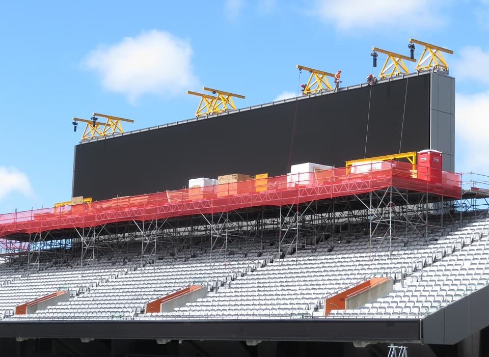 Large LED display screen installation on steel support framework integrated with concrete stadium structure Eden Park Auckland