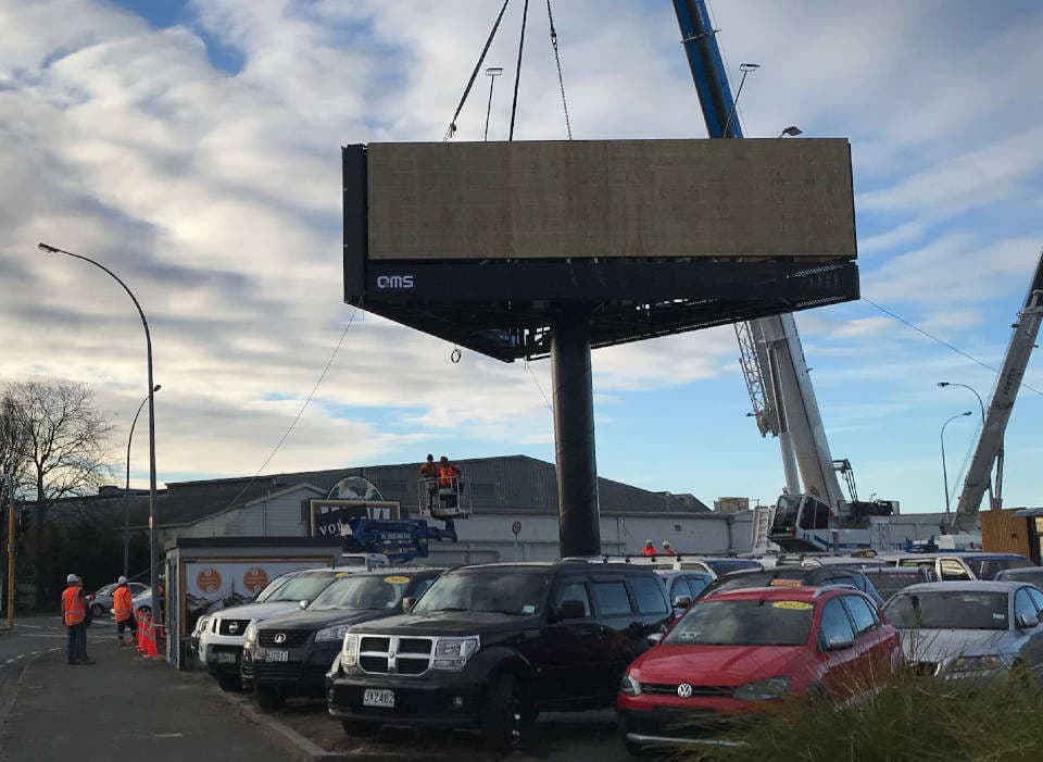 Crane lifting steel billboard structure with concrete foundations and screw piles Greenwood Street Hamilton construction